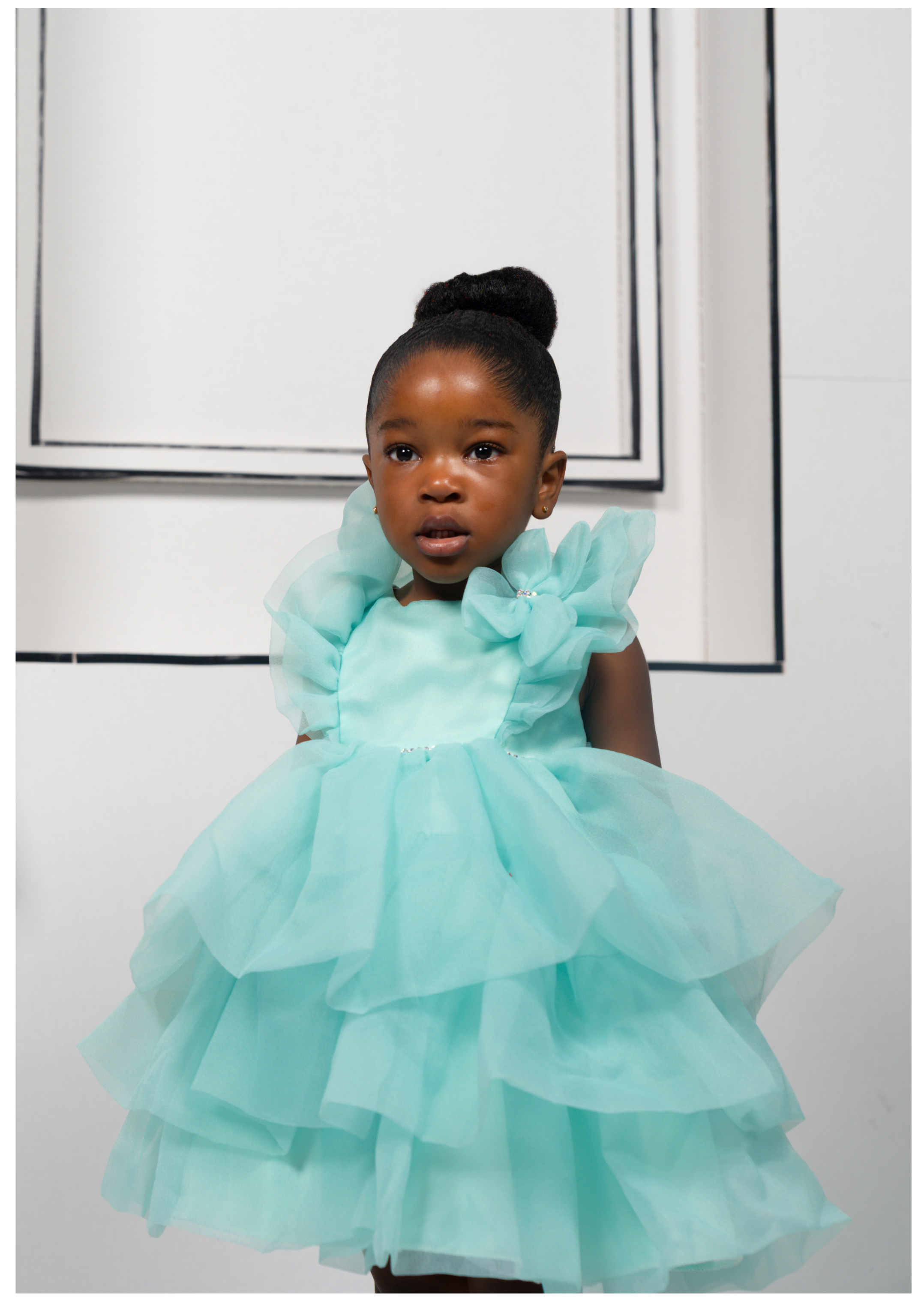 Toddler girl wearing mint green ruffle dress with floral shoulder design, perfect for birthday or flower girl look